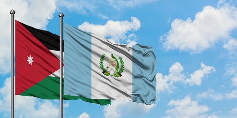Jordan and Guatemala flag waving in the wind against white cloudy blue sky together. Diplomacy concept, international relations.