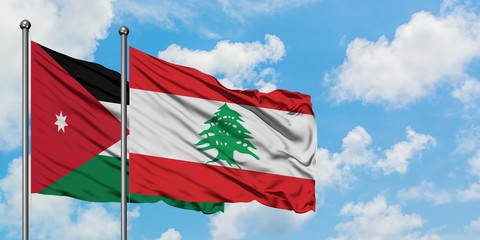 Jordan and Lebanon flag waving in the wind against white cloudy blue sky together. Diplomacy concept, international relations.