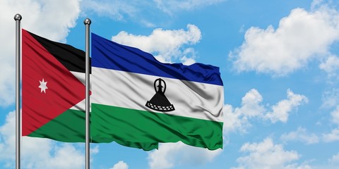 Jordan and Lesotho flag waving in the wind against white cloudy blue sky together. Diplomacy concept, international relations.