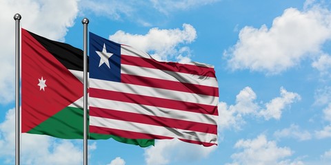 Jordan and Liberia flag waving in the wind against white cloudy blue sky together. Diplomacy concept, international relations.