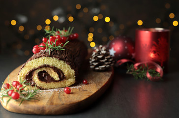 Tronchetto di Natale al cioccolato, Buche de Noel sul tagliere di legno. Decorazioni natalizie su...