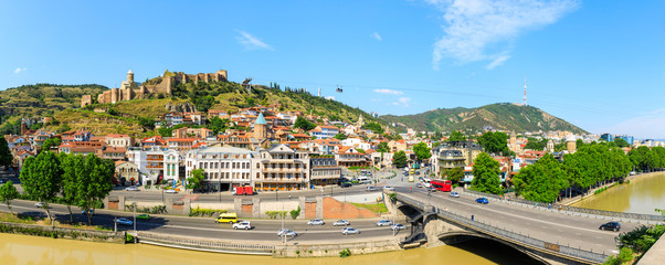 Panorama of the old town on Sololaki hill, crowned with Narikala fortress, the Kura river and cars traffic with blure in Tbilisi, Georgia © miklyxa