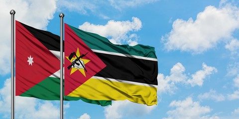 Jordan and Mozambique flag waving in the wind against white cloudy blue sky together. Diplomacy concept, international relations.