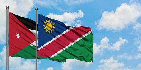 Jordan and Namibia flag waving in the wind against white cloudy blue sky together. Diplomacy concept, international relations.