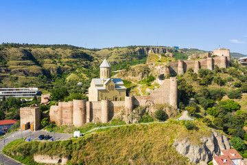 Panorama of the old town on Sololaki hill, crowned with Narikala fortress, the Kura river and cars traffic with blure in Tbilisi, Georgia