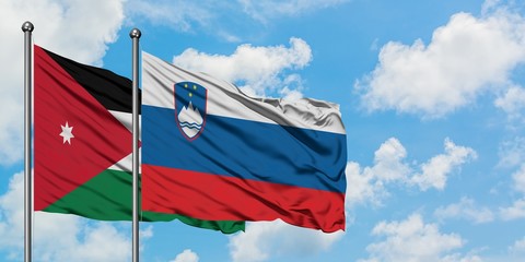 Jordan and Slovenia flag waving in the wind against white cloudy blue sky together. Diplomacy concept, international relations.