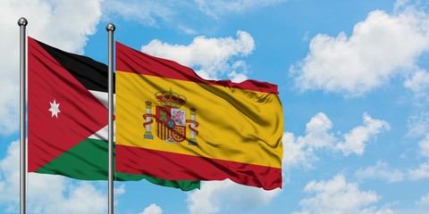 Jordan and Spain flag waving in the wind against white cloudy blue sky together. Diplomacy concept, international relations.