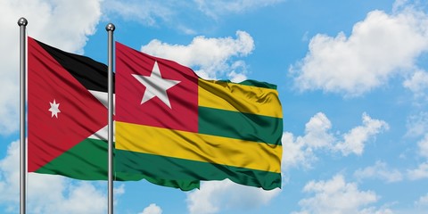 Jordan and Togo flag waving in the wind against white cloudy blue sky together. Diplomacy concept, international relations.