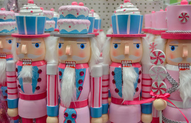 A wooden figure of a classic Nutcracker, in an unusual pink and blue shape. With the white beard on...