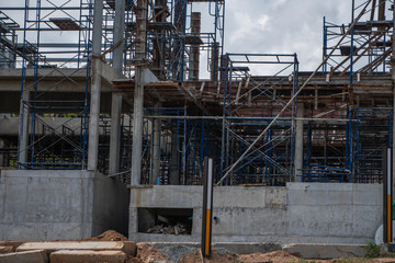 Building and Construction Site in progress. Building construction site against cloudy sky. Metal...