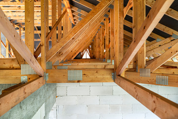 Roof trusses covered with a membrane on a detached house under construction, view from the inside,...