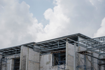 Building and Construction Site in progress. Building construction site against cloudy sky. Metal...