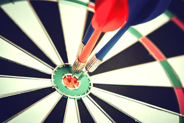 Dart arrow hitting in the target center of dartboard