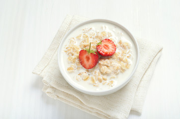 Tasty oatmeal with strawberry slices in bowl