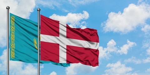 Kazakhstan and Denmark flag waving in the wind against white cloudy blue sky together. Diplomacy concept, international relations.