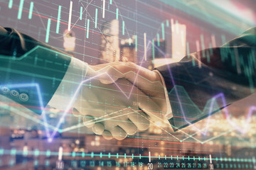 Double exposure of financial graph on cityscape background with two businessman handshake. Concept of stock market deal