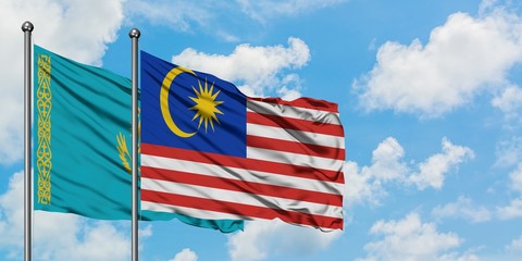 Kazakhstan and Malaysia flag waving in the wind against white cloudy blue sky together. Diplomacy concept, international relations.