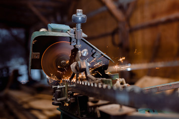 automatized old whetting machine, whet saw blade. close-up of freezed motion sparkle