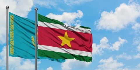 Kazakhstan and Suriname flag waving in the wind against white cloudy blue sky together. Diplomacy concept, international relations.