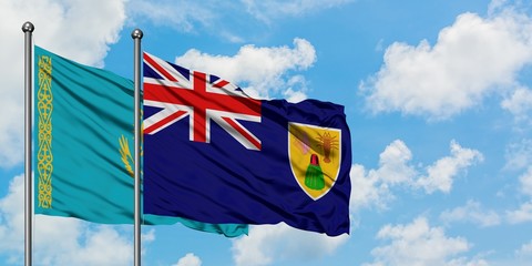 Kazakhstan and Turks And Caicos Islands flag waving in the wind against white cloudy blue sky together. Diplomacy concept, international relations.