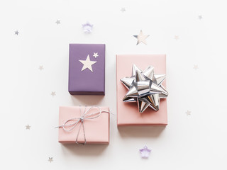Holiday presents. Gifts wrapped in pale pink and violet paper with silver ribbons and bow. Stars...