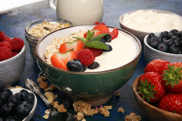 Tasty homemade granola served on table. Healthy breakfast with a bowl of oatmeal with banana, blueberries, strawberries and healthy food for Breakfast