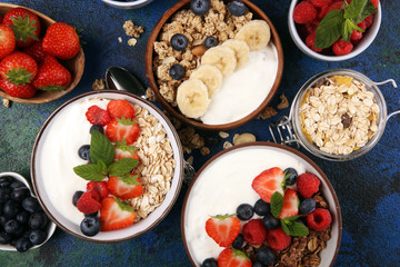 Tasty homemade granola served on table. Healthy breakfast with a bowl of oatmeal with banana, blueberries, strawberries and healthy food for Breakfast