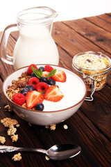 Tasty homemade granola served on table. Healthy breakfast with a bowl of oatmeal with banana, blueberries, strawberries and healthy food for Breakfast