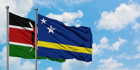 Kenya and Curacao flag waving in the wind against white cloudy blue sky together. Diplomacy...