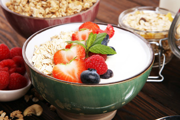 Tasty homemade granola served on table. Healthy breakfast with a bowl of oatmeal with banana, blueberries, strawberries and healthy food for Breakfast
