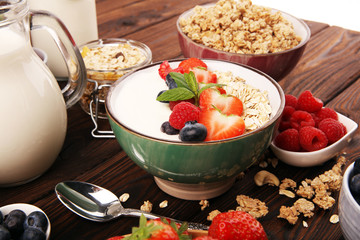 Tasty homemade granola served on table. Healthy breakfast with a bowl of oatmeal with banana, blueberries, strawberries and healthy food for Breakfast