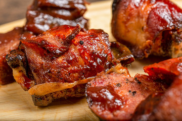 Combination bbq sausage brisket and bacon wrapped jalapeno pepper up close on cutting board