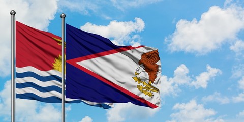 Kiribati and American Samoa flag waving in the wind against white cloudy blue sky together....