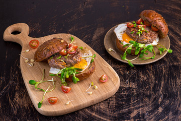 Burger with cherry tomato, green sprout and fried egg