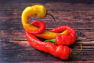 Fashionable ugly organic product-hot pepper. Two red and one yellow deformed peppers with damaged...