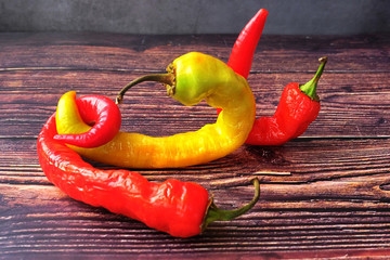 Fashionable ugly organic product-hot pepper. Two red and one yellow deformed peppers with damaged...