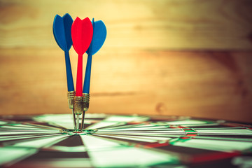 Dart arrow hitting in the target center of dartboard