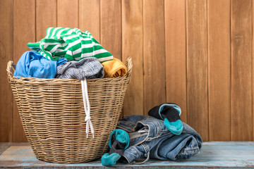 Clothes in a laundry wooden basket on wood table