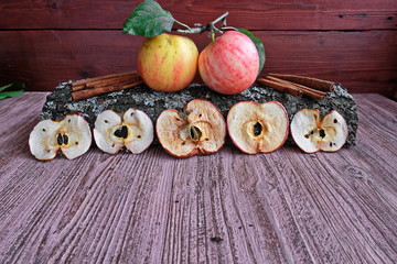 Organic Apple chips (slices) on a wooden background, next to fresh fruit.Dried Apple slices are a healthy vegetarian fruit snack or cooking ingredient. The concept is a healthy diet. Copy space..