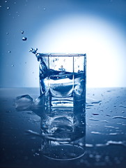Ice Cubes Splashing Into Glass Of Water.