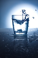 Water splash in glass with ice.