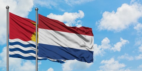 Kiribati and Netherlands flag waving in the wind against white cloudy blue sky together. Diplomacy concept, international relations.