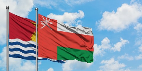 Kiribati and Oman flag waving in the wind against white cloudy blue sky together. Diplomacy concept, international relations.