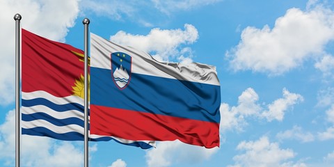 Kiribati and Slovenia flag waving in the wind against white cloudy blue sky together. Diplomacy concept, international relations.