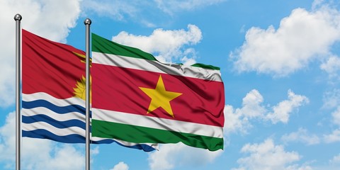 Kiribati and Suriname flag waving in the wind against white cloudy blue sky together. Diplomacy concept, international relations.