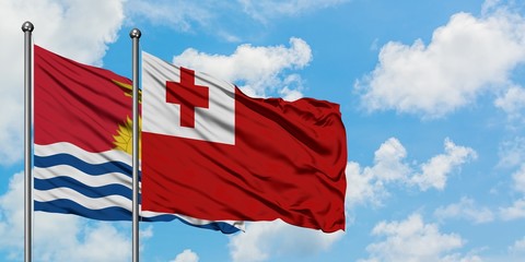 Kiribati and Tonga flag waving in the wind against white cloudy blue sky together. Diplomacy concept, international relations.