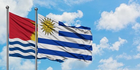Kiribati and Uruguay flag waving in the wind against white cloudy blue sky together. Diplomacy concept, international relations.