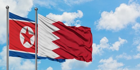 North Korea and Bahrain flag waving in the wind against white cloudy blue sky together. Diplomacy concept, international relations.