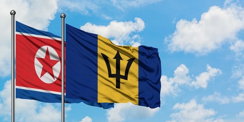 North Korea and Barbados flag waving in the wind against white cloudy blue sky together. Diplomacy concept, international relations.