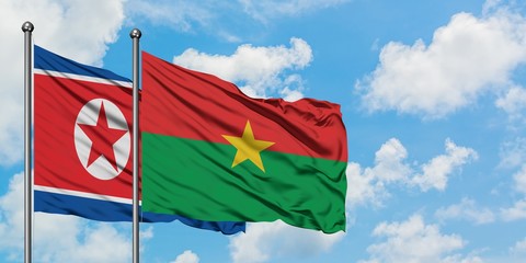 North Korea and Burkina Faso flag waving in the wind against white cloudy blue sky together. Diplomacy concept, international relations.